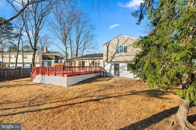 back of property with fence and a wooden deck