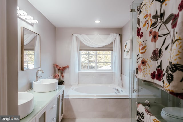 full bathroom featuring vanity, separate shower and tub, and toilet