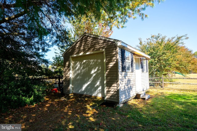 view of home's exterior featuring an outdoor structure, a garage, and a lawn