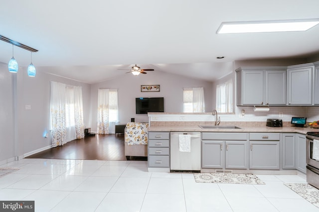 kitchen featuring appliances with stainless steel finishes, lofted ceiling, sink, and a wealth of natural light