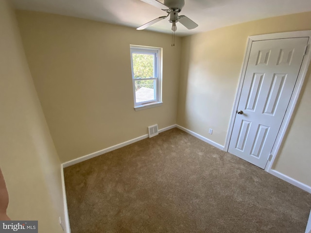 empty room with ceiling fan and carpet