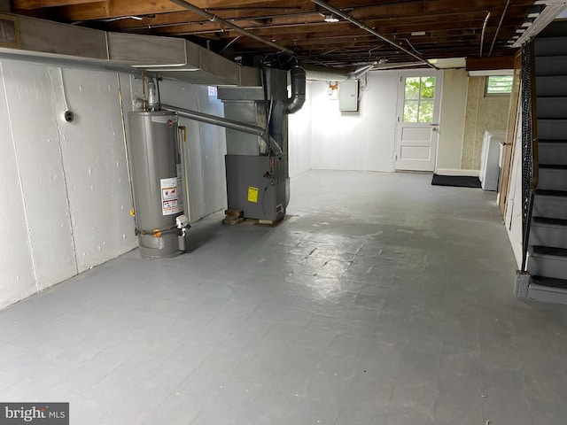 basement with heating unit, electric panel, and water heater