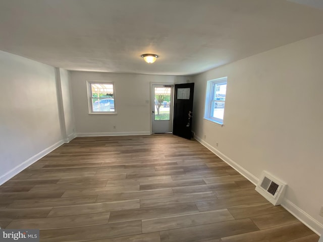 foyer entrance with a healthy amount of sunlight and dark hardwood / wood-style floors