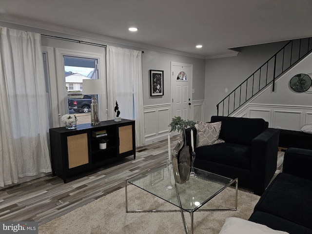 living room with hardwood / wood-style flooring and crown molding