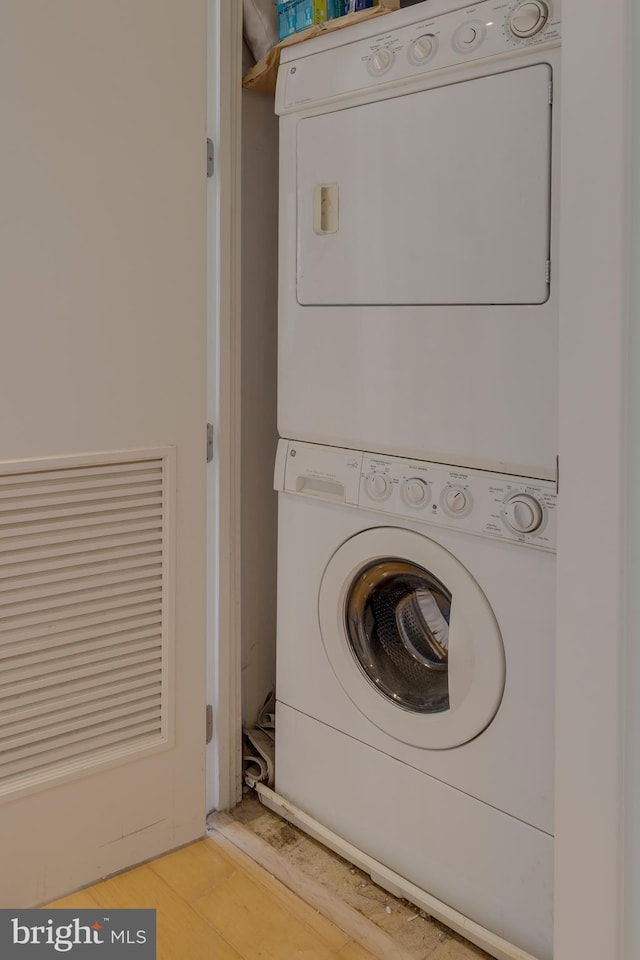 laundry area featuring light hardwood / wood-style floors and stacked washer and dryer