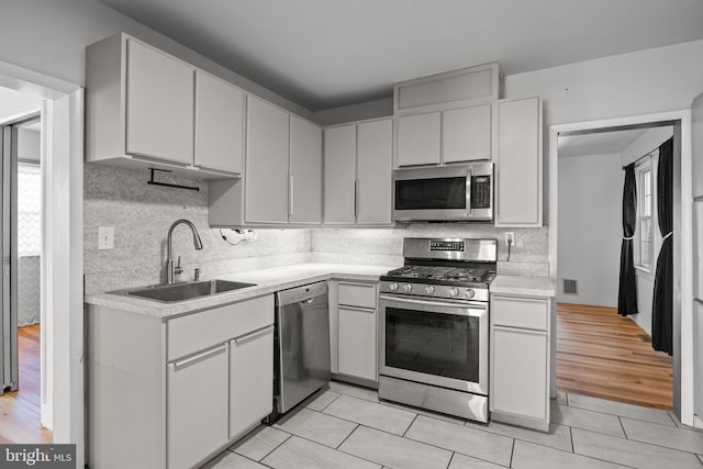 kitchen with light hardwood / wood-style flooring, white cabinetry, stainless steel appliances, and sink