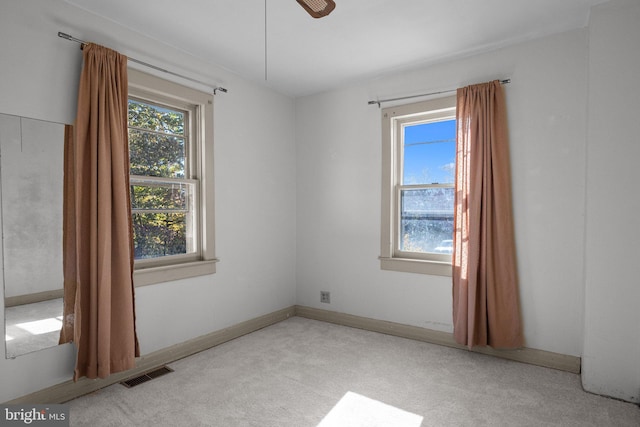 carpeted spare room with ceiling fan