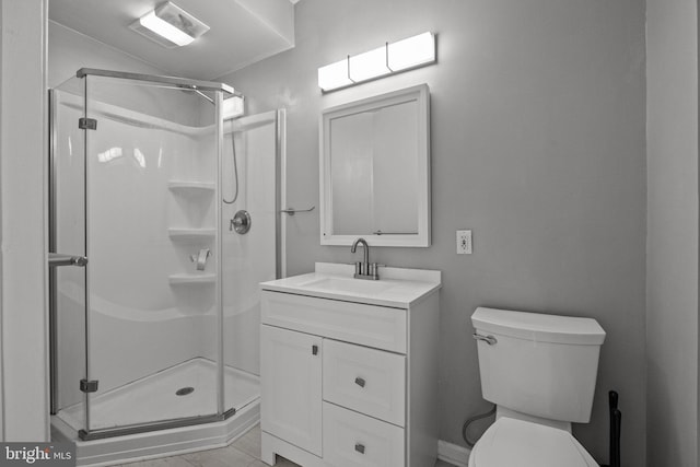 bathroom featuring toilet, vanity, tile patterned floors, and a shower with door