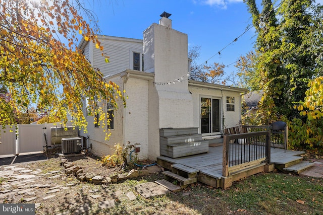 back of house with central AC and a wooden deck