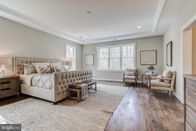 bedroom with hardwood / wood-style flooring and a tray ceiling