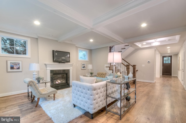 living room with light hardwood / wood-style floors, ornamental molding, plenty of natural light, and a tile fireplace