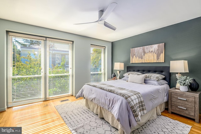 bedroom with light hardwood / wood-style floors, ceiling fan, and multiple windows