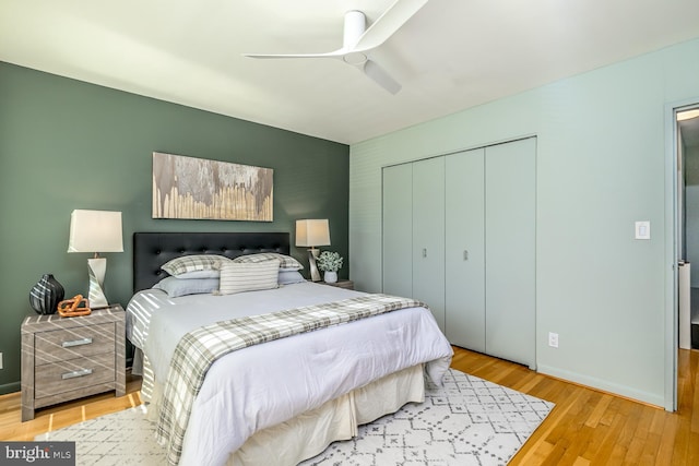 bedroom with hardwood / wood-style floors, ceiling fan, and a closet