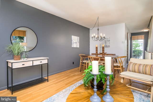 dining area with hardwood / wood-style floors and a chandelier