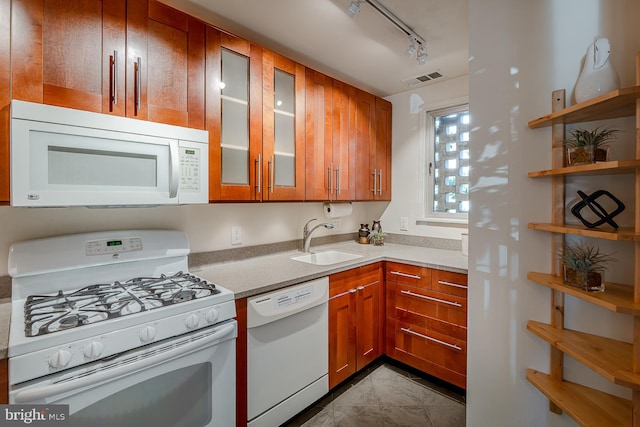 kitchen with light tile patterned floors, white appliances, sink, and track lighting