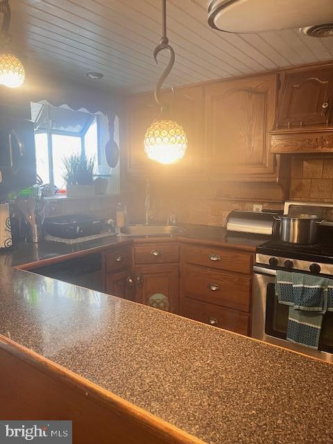 kitchen with sink, stainless steel range, dishwashing machine, and wooden ceiling