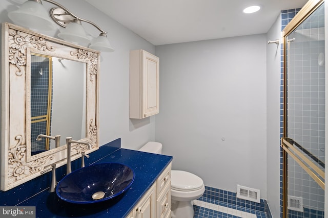 bathroom with toilet, an enclosed shower, vanity, and tile patterned flooring