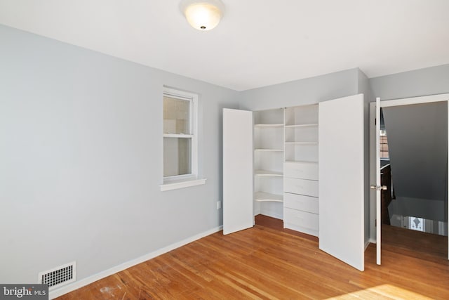 unfurnished bedroom featuring a closet and hardwood / wood-style flooring