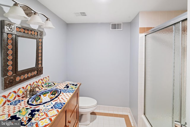 bathroom featuring toilet, walk in shower, vanity, and tile patterned flooring