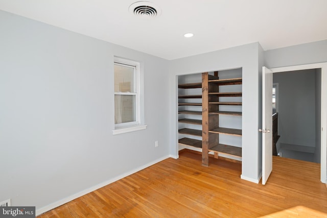 unfurnished bedroom with wood-type flooring and a closet