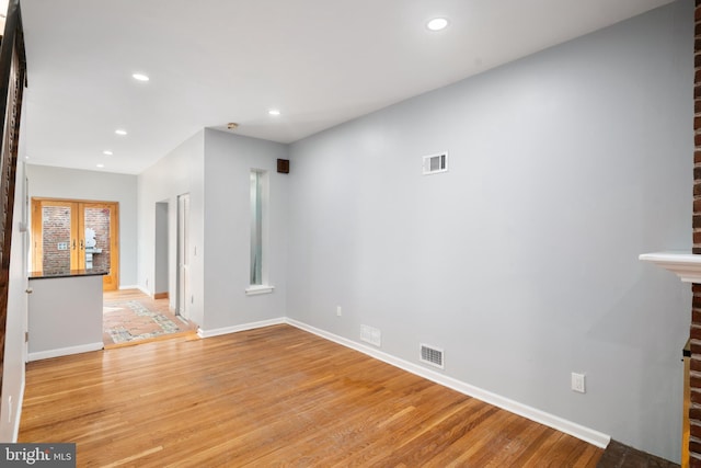 unfurnished living room featuring french doors and light wood-type flooring