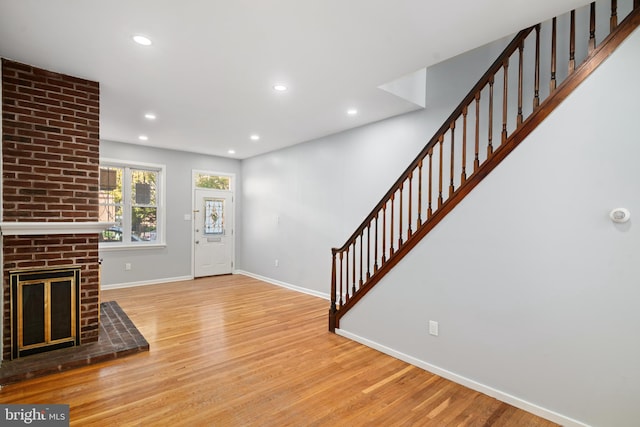 entryway with a fireplace and light wood-type flooring