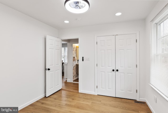 unfurnished bedroom with light hardwood / wood-style floors and a closet