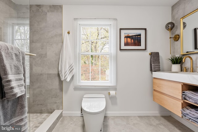 bathroom with tiled shower, vanity, toilet, and a healthy amount of sunlight