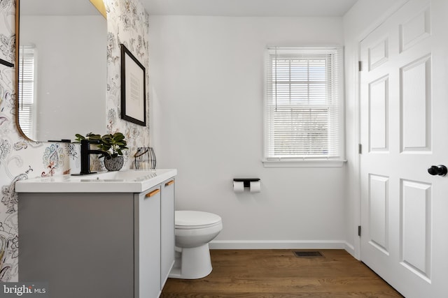 bathroom with hardwood / wood-style floors, vanity, and toilet