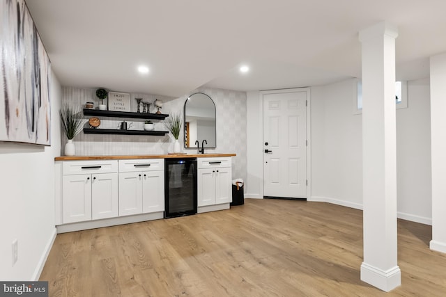 bar with white cabinetry, light hardwood / wood-style flooring, wine cooler, and wooden counters