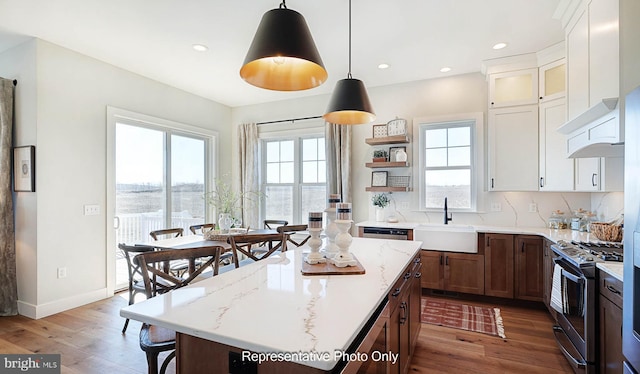 kitchen with sink, stainless steel range with gas cooktop, pendant lighting, and a healthy amount of sunlight