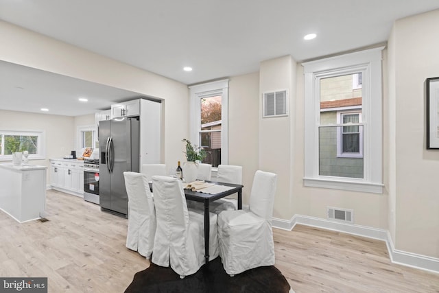 dining space featuring a barn door and light hardwood / wood-style floors