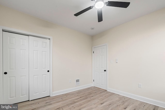 unfurnished bedroom with light hardwood / wood-style flooring, a closet, and ceiling fan