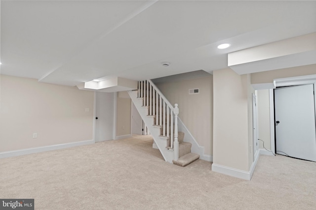 basement featuring light carpet