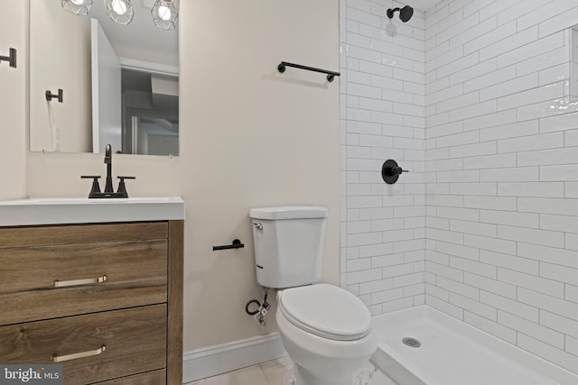 bathroom featuring vanity, tiled shower, toilet, and tile patterned floors