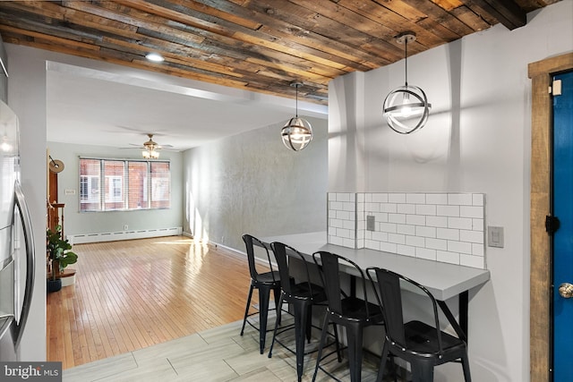 dining space with wood ceiling, a baseboard heating unit, ceiling fan, light hardwood / wood-style flooring, and beamed ceiling