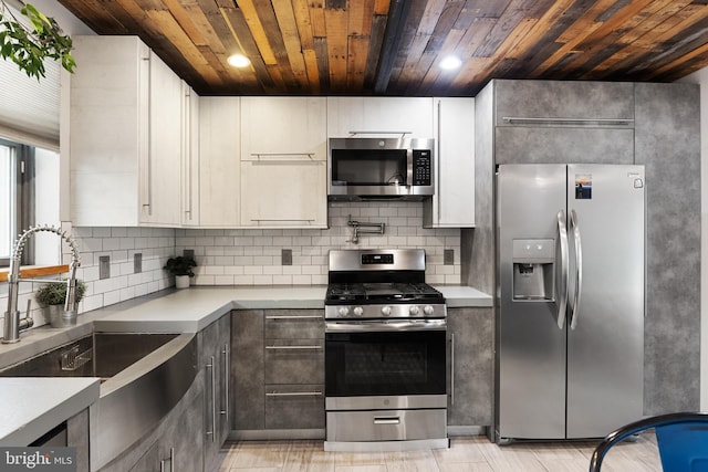 kitchen with white cabinets, stainless steel appliances, backsplash, and wooden ceiling