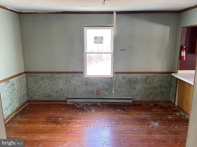 unfurnished room with wood-type flooring, ornamental molding, and a baseboard radiator