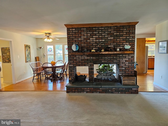 living room with ceiling fan, carpet, and a fireplace