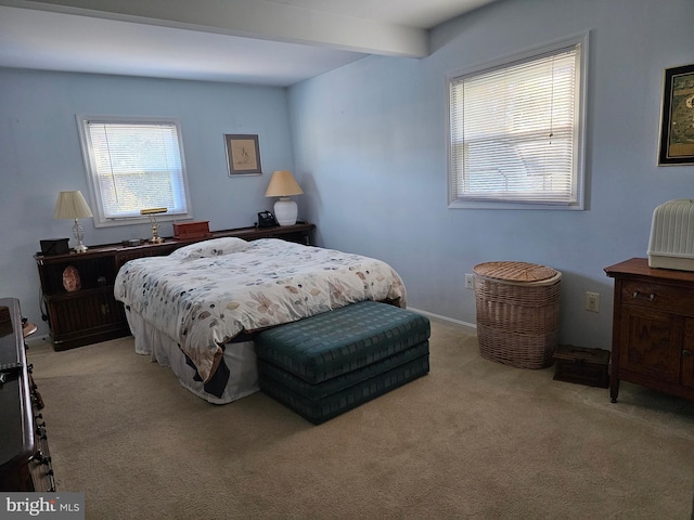 carpeted bedroom with multiple windows and beam ceiling