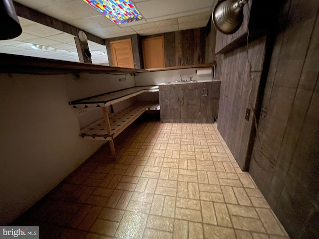 basement featuring sink and a drop ceiling