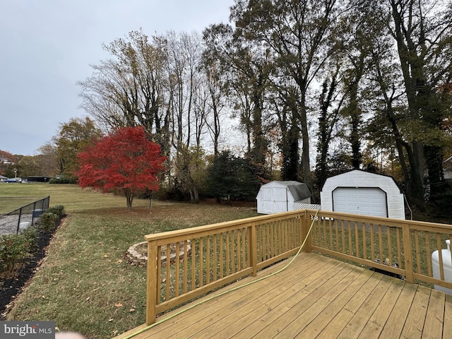 deck with a garage, a yard, and a storage unit