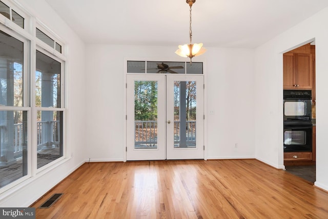 unfurnished dining area featuring french doors, light hardwood / wood-style floors, and ceiling fan