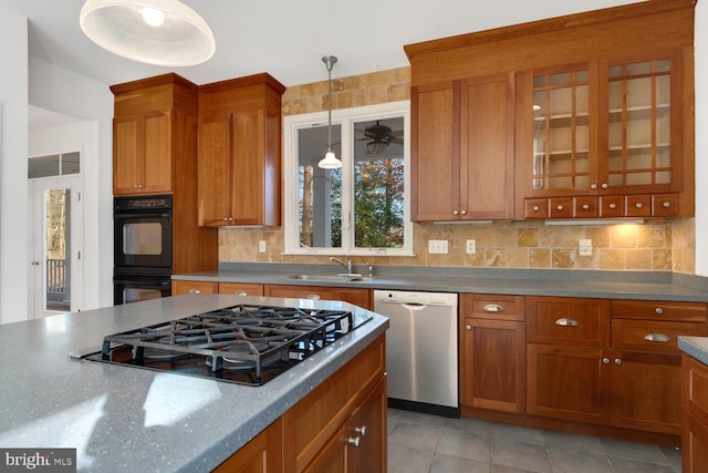 kitchen with appliances with stainless steel finishes, tasteful backsplash, sink, decorative light fixtures, and light tile patterned flooring