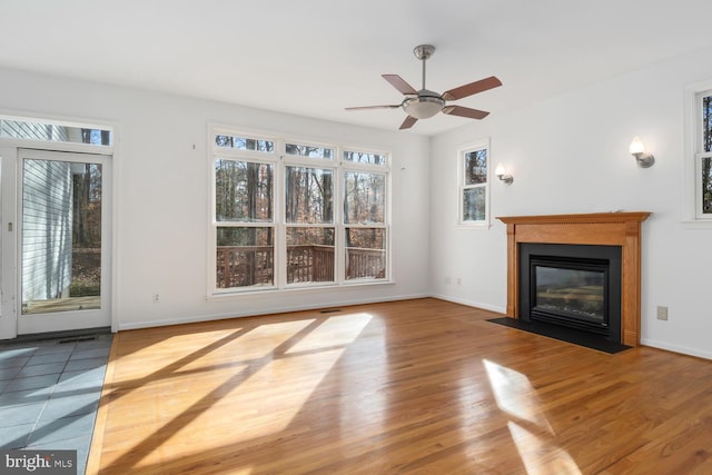 unfurnished living room featuring wood-type flooring and ceiling fan