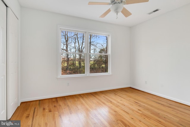 unfurnished bedroom with ceiling fan, a closet, and light hardwood / wood-style floors