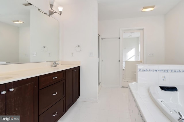 bathroom with tile patterned floors, vanity, a chandelier, and a relaxing tiled tub