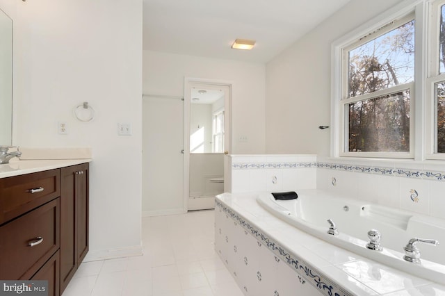 bathroom with tiled bath, tile patterned flooring, and vanity