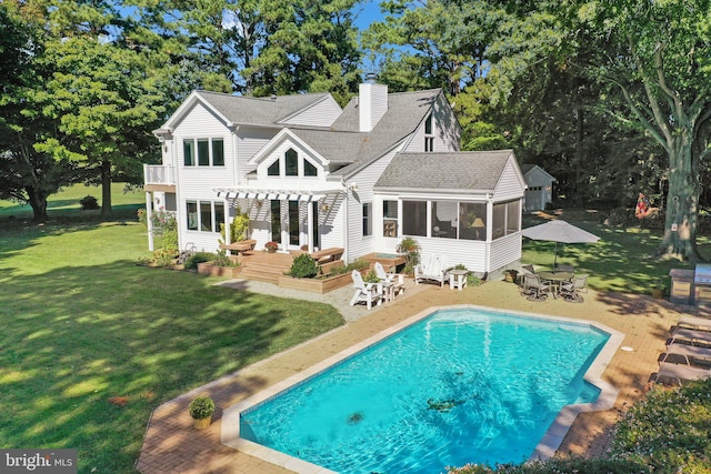 back of property with a patio area, a sunroom, a lawn, and a pergola