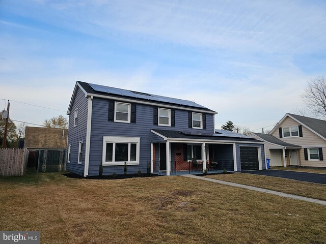 view of front of home with a front lawn, a garage, a porch, and solar panels